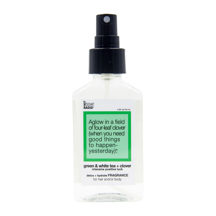 A green and white tea clover scented hair and body mist on a white background.