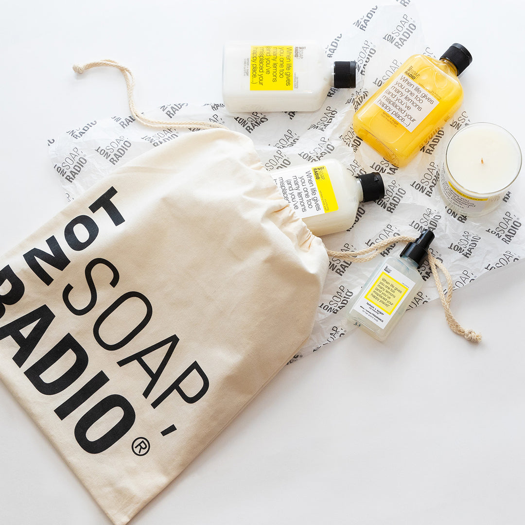 The lemon scented collection flatlay on top of tissue paper and gift bag.