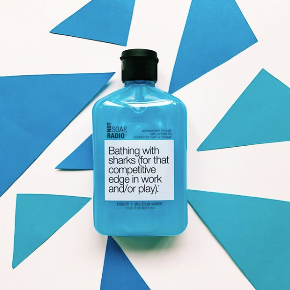 A beach and sky blue water scented bubble bath gel on top of blue triangle cut outs.