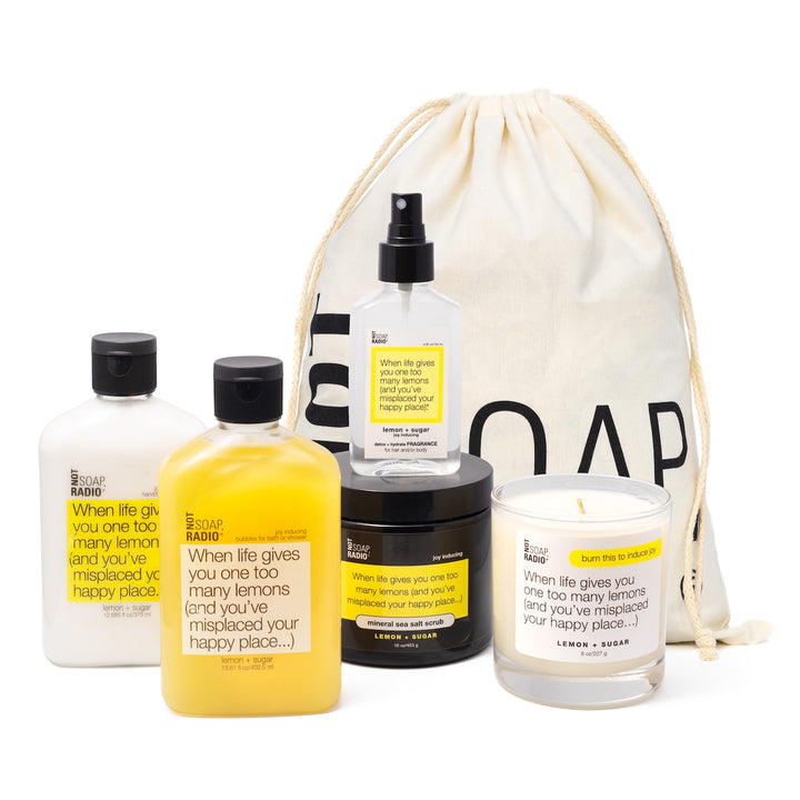 Lemon and sugar scented bath and body products standing in front of gift bag.