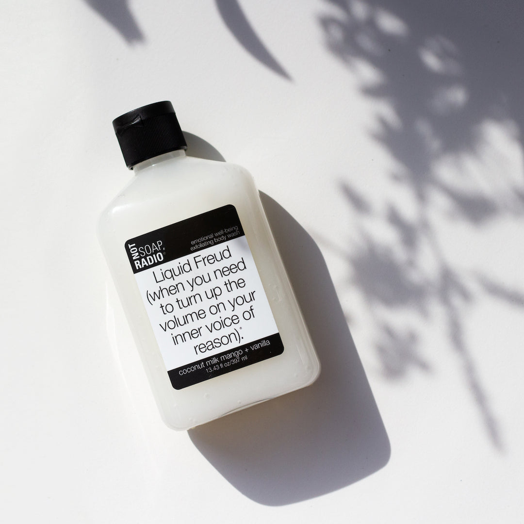 Coconut mango vanilla scented aromatherapy bath and body care scrub, on a white background with flower shadows