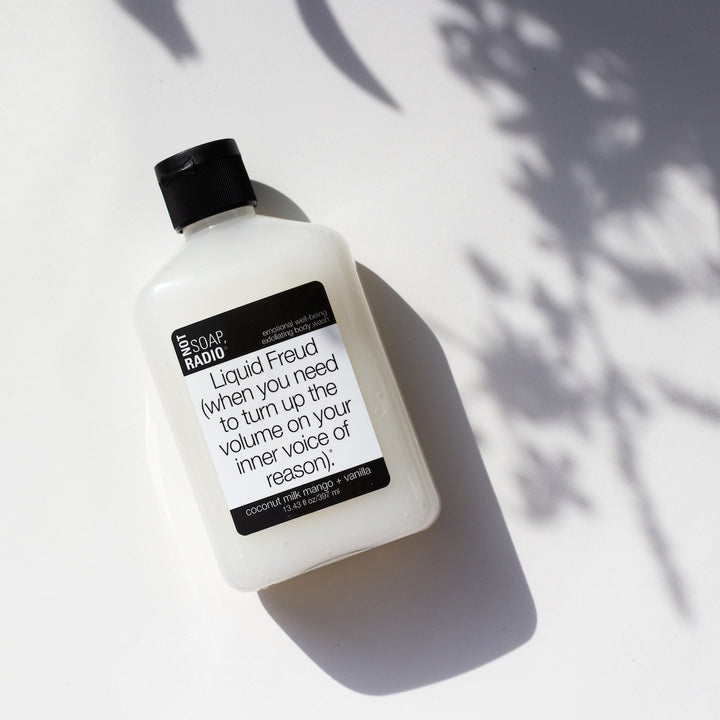 Coconut mango vanilla scented aromatherapy bath and body care scrub, on a white background with flower shadows