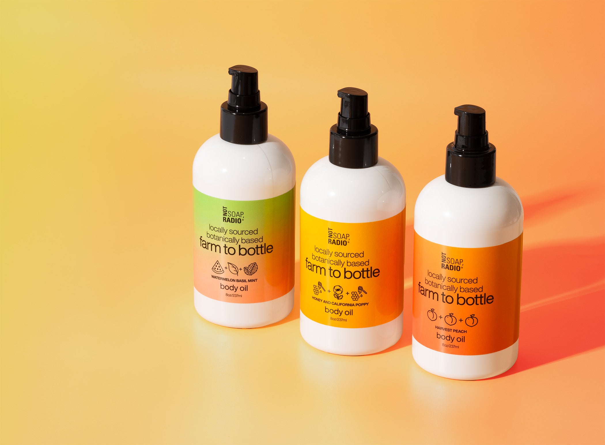 Farm to bottle body oils in a row on an orange background. Featuring watermelon basil mint, honey and california poppy and harvest peach fragrances.