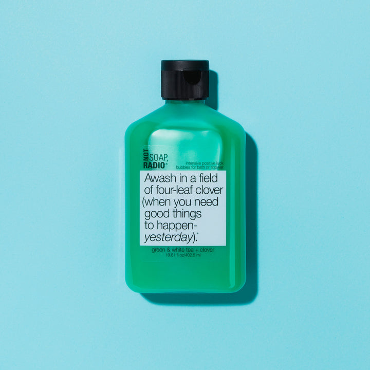 A shamrock oil based shower gel flat lay on a blue background.