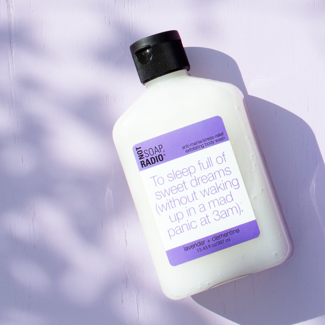 Lavender clementine scented exfoliating body wash on a purple background