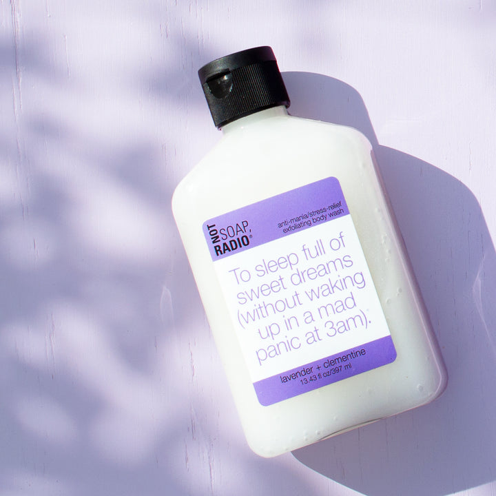 Lavender clementine scented exfoliating body wash on a purple background