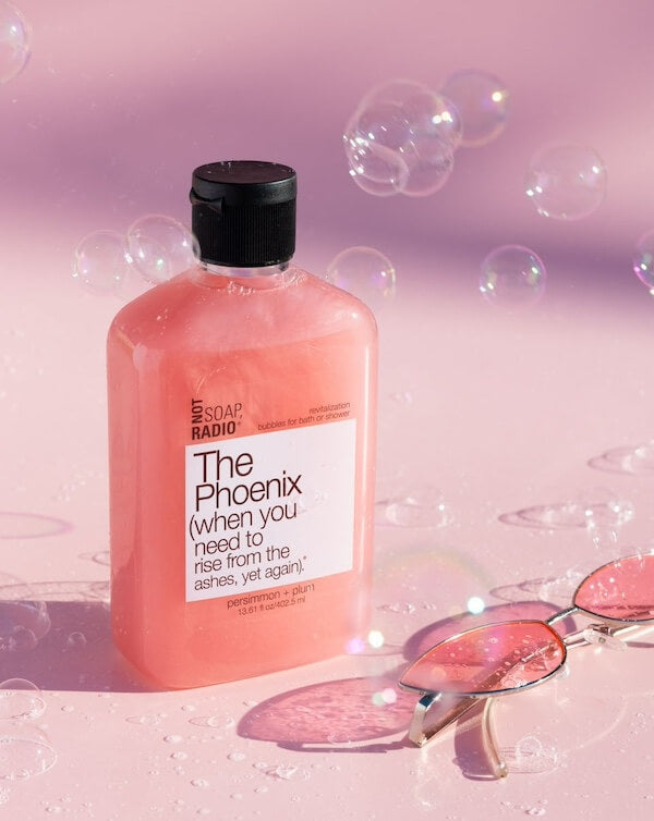 The Phoenix bubble bath surrounded by bubbles on a pink background