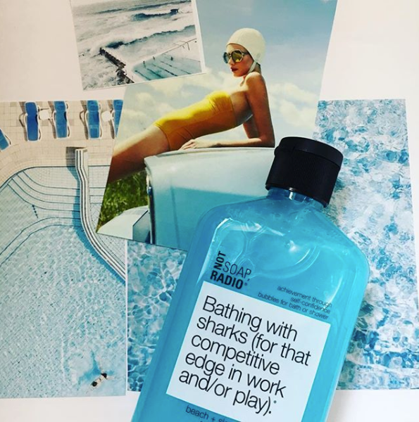 An artsy arrangement of blue aesthetic collage cutouts underneath a blue colored shower gel.