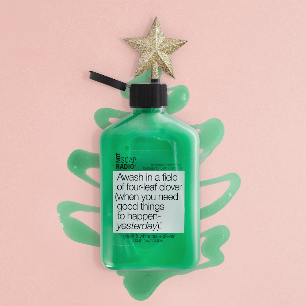 A green body wash on top of a Christmas tree shaped gel with a gold star coming out of the lid.