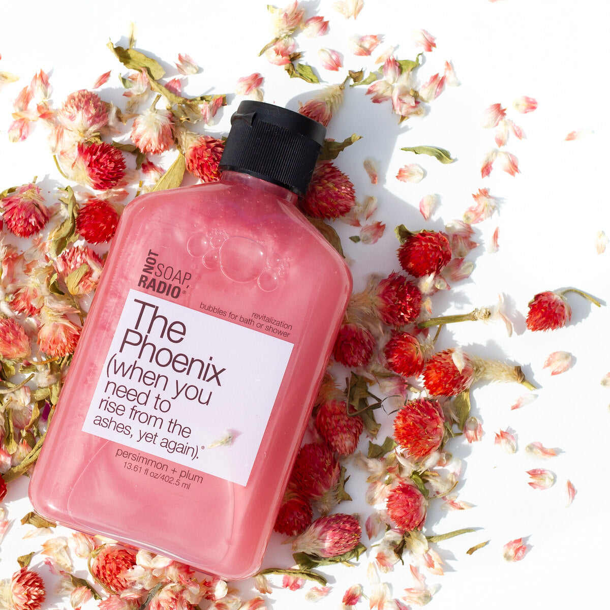 The phoenix bubble bath, laying in a pile of dried pink flowers